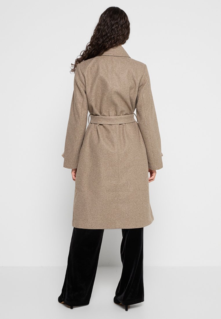 Cappotto in misto lana marrone con vita sbloccata, maniche lunghe e silhouette leggermente aderente. Texture liscia e taglio dritto.