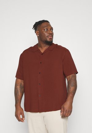 Camisa marrón de manga corta con botones, cuello clásico y botones negros, hecha de un tejido ligero. Presenta un ajuste relajado y una textura suave.