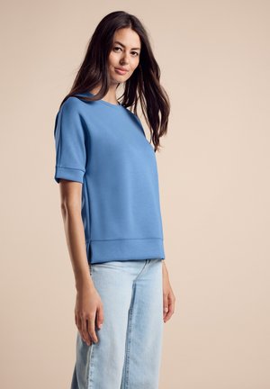 Blauwe sweatshirt met korte mouwen en een ronde hals, met een ontspannen pasvorm en een gladde textuur, gecombineerd met lichtblauwe jeans.