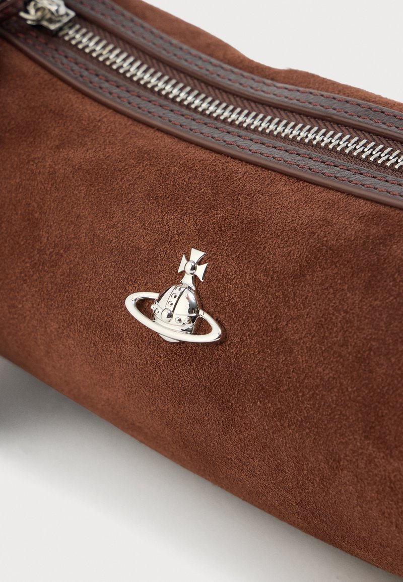 Brown suede bag featuring a silver charm of a spaceship with a ring and cross detail, complemented by a patterned zipper and matching stitching.
