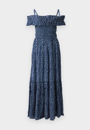 Navy blue maxi dress with white polka dots, off-the-shoulder ruffled neckline, smocked bodice, and tiered skirt design.