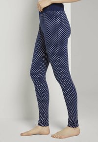 Marine legging met witte stippen, gemaakt van rekbaar materiaal. Beschikt over een brede tailleband voor comfort en een getailleerd ontwerp.