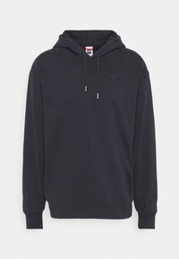 Tmavě námořnická mikina s kapucí z měkké látky, vybavená klokánkou, šňůrkami na stažení, žebrovanými manžetami a malým logem na hrudi.