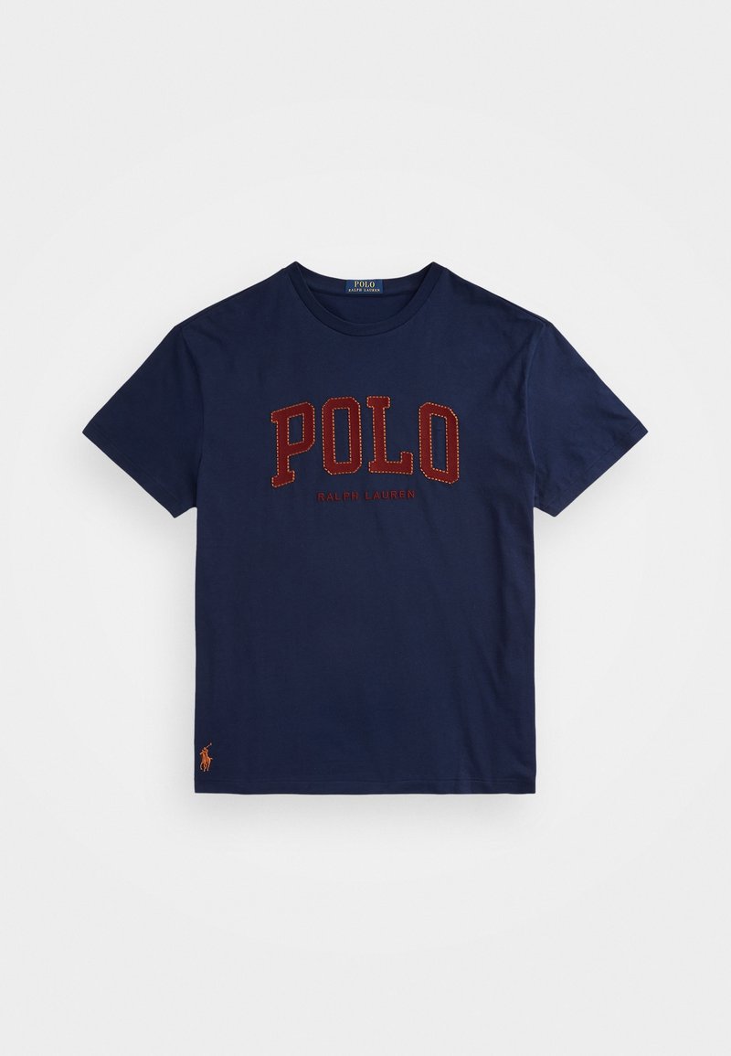 T-shirt in cotone navy con logo rosso "POLO" e testo "RALPH LAUREN", con piccolo accento dell'logo arancione del polo sull'orlo. Maniche corte, colletto girocollo.
