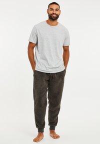 Grijze katoenen t-shirt en donkergrijze fleece joggingbroek met elastische boorden, met een zachte textuur en een ruime pasvorm. Geen zichtbare patronen.