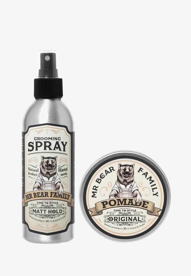 Hoitoainetta sisältävä suihke hopeisessa suihkepullossa, jossa on musta suihkunokka; pomade pyöreässä tinassa, jossa on karhuteema ja vaaleancremi värinen etiketti.