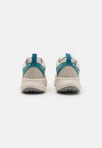 Lightweight running shoes in white and teal, featuring a mesh upper, textured heel, and rubber outsole with prominent traction patterns.