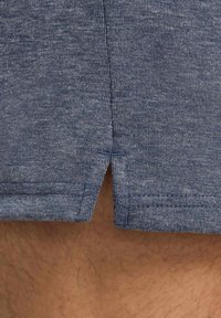 Herren Shorts aus Baumwolle in Marineblau mit melierter Textur, seitlichen Schlitzen am Saum und sauber genähten Kanten für eine entspannte Passform.