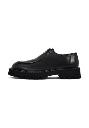 Scarpa nera in pelle con lacci, suola spessa e robusta e tacco basso, mostrata di profilo su sfondo bianco.