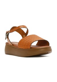 Sandali in pelle intrecciata marrone con punta aperta, cinturino alla caviglia regolabile e suola platform spessa e rigata.