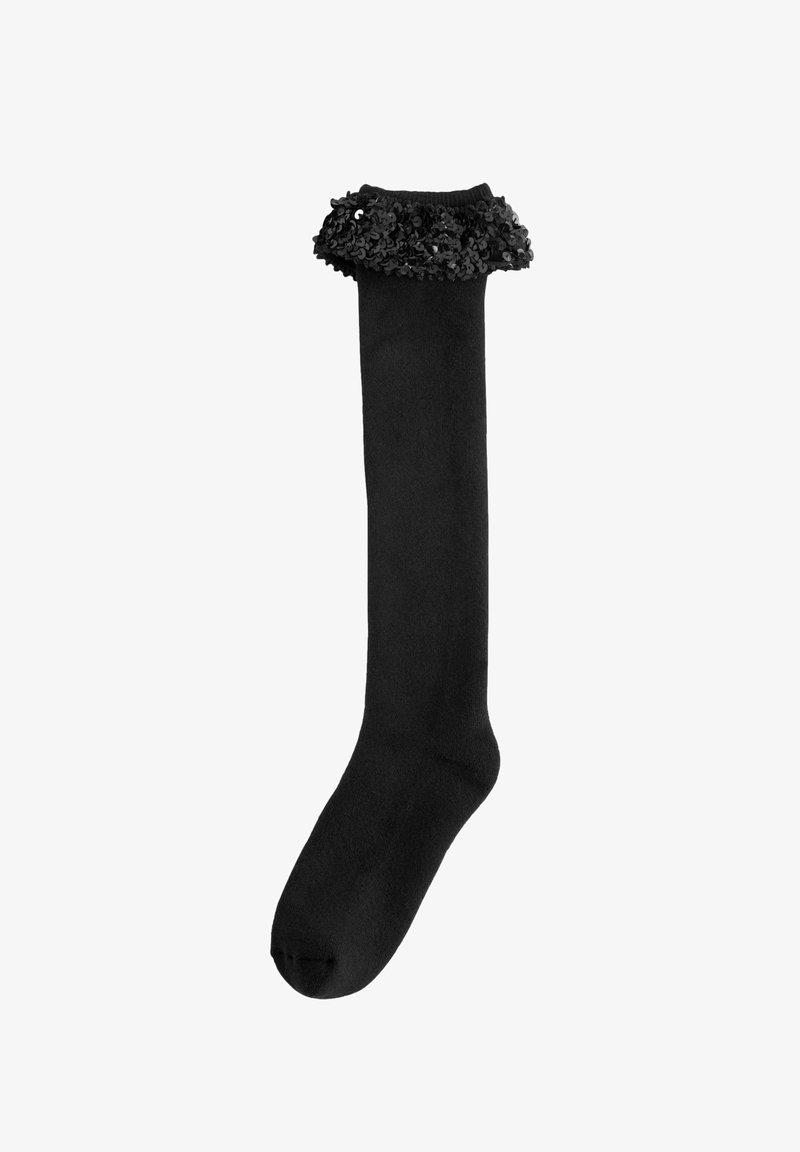 Black knee-high sock with a ruffled cuff made of black sequins. Smooth texture, fitted shape, and reinforced toe area for durability.