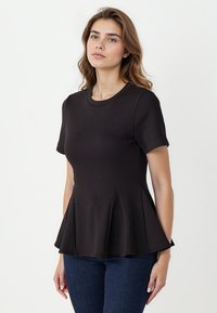 Czarny top peplum z dopasowanego materiału dżersejowego, z krótkimi rękawami i okrągłym dekoltem; ozdobiony pionowymi fałdami dla dodatkowego efektu.