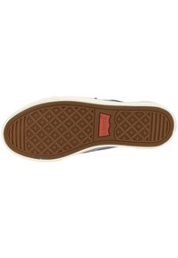 Semelle de chaussure en caoutchouc marron avec un motif en losange, présentant un bord texturé et un logo de marque visible. Flancs blancs accentuant le design.