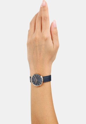 Marineblaues Lederarmbanduhr mit einem runden Gehäuse aus Edelstahl, dunklem Zifferblatt, minimalistischen Stundenmarkierungen und roségoldenen Akzenten.