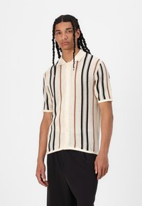Kurzarm-Polohemd in Creme mit horizontalen Streifen in Schwarz, Braun und Orange, aus strukturiertem Strick und mit Knopfverschluss.