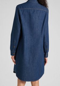 Denimhemdkleid mit langen Ärmeln, dunkler blauer Farbe, geknöpften Manschetten und abgerundetem Saum, das einen klassischen Kragen und eine weiche Textur aufweist.