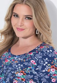 Navy Hemd mit Blumenmuster und rundem Ausschnitt, das weiße Umrisse von Blumen und farbenfrohe Akzente zeigt. Weicher Stoff und lockere Passform.