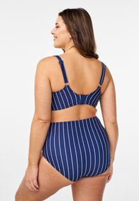 Marine gestreepte bikini met witte verticale lijnen. De top heeft verstelbare bandjes en een haaksluiting. Hooggesneden broek voor bedekking.
