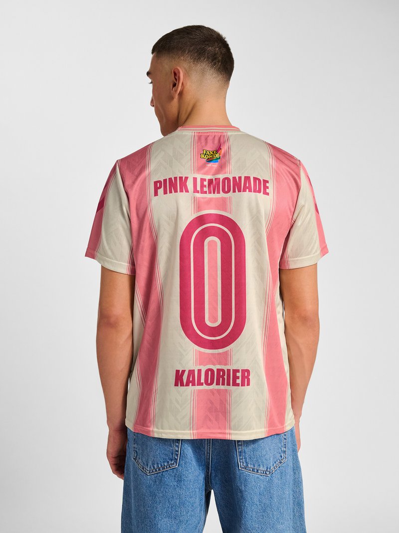 Mann trägt ein rosa-beigefarben gestreiftes Hemd mit dem Schriftzug und Logo „Pink Lemonade 0 Kalorien“ auf dem Rücken, kombiniert mit blauen Jeans.