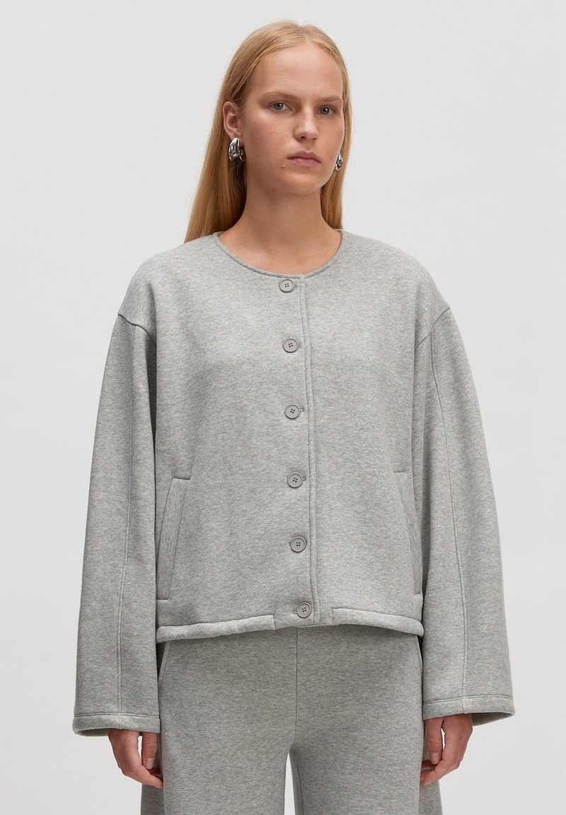 Grijze, oversized sweatshirt-jack gemaakt van zachte stof, met een ronde halslijn, knopen aan de voorkant en zijzakken. Glad textuur, casual ontwerp.
