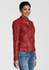 Rote Lederjacke mit hohem Kragen, figurbetontem Design und Reißverschlusstaschen. Glatte Textur mit gesteppten Details an den Schultern.
