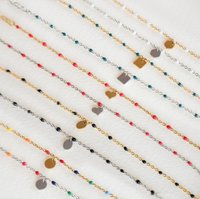 Kettingarmbanden in metaal met kleurrijke kralen. Bevat gouden, zilveren en zwarte accenten, met hart- en geometrische bedels. Diverse kleuren aanwezig.