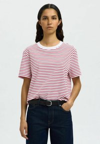Red and white striped t-shirt with a round neckline and short sleeves, worn with dark denim jeans and a black belt. Simple, casual design.