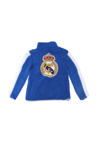 Giacca in pile blu con colletto alto, strisce laterali bianche e logo ricamato del Real Madrid con corona sul retro.