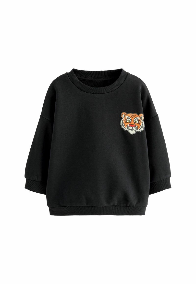 Sweat-shirt noir à manches longues avec poignets et ourlet côtelés, présentant un petit visage de tigre orange brodé sur la poitrine gauche.