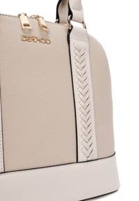 Borsa a mano in pelle beige con dettagli intrecciati ai lati, hardware dorato e forma arrotondata. Presenta una texture liscia con accenti neri a contrasto.