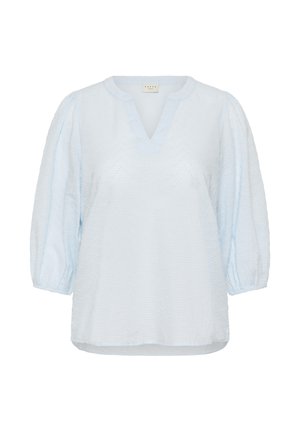 Blouse bleu clair texturée avec manches ballon trois-quarts et décolleté en V.