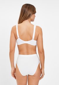 Witte beha en hoog-geknoopte slip gemaakt van gladde stof. De beha heeft verstelbare bandjes en een haaksluiting; beiden hebben een naadloos ontwerp.