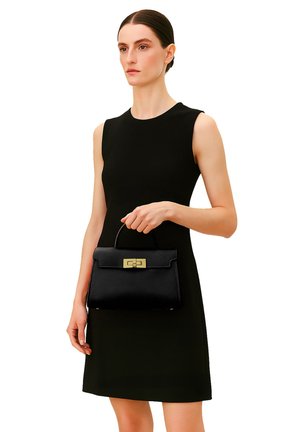 Borsa in pelle nera con un design strutturato, caratterizzata da un cappuccio frontale e una chiusura dorata. Texture liscia e una maniglia corta per il trasporto.