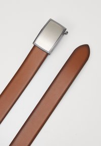 Cinturón de cuero marrón con una hebilla metálica rectangular; textura suave, diseño minimalista, brillo sutil en la hebilla, extremo afilado en el cinturón.