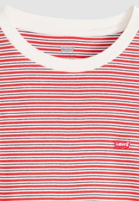 Röd-och-vitrandig t-shirt med vit rundhals. Har en liten röd Levi's-logotyp på framsidan. Mjuk bomullsmaterial.