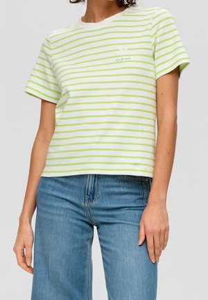 Kobieta ubrana w biały T-shirt z jasnooliwkowymi poziomymi paskami oraz napisem "Love Yourself", w duecie z niebieskimi dżinsami.