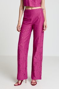 Pantalon taille haute fuchsia à motif en dentelle, coupe décontractée, associé à des talons à brides. Caractérisé par des découpes complexes et une texture lisse.