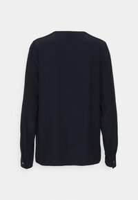 Blouse à manches longues de couleur bleu marine foncé en tissu lisse. Dotée d'un col arrondi et de poignets boutonnés. Design simple et dépourvu d'ornements.
