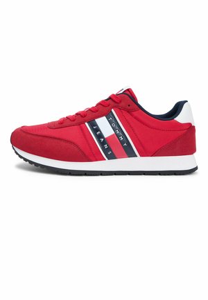 Rode sportieve sneaker met een wit, marineblauw en rood gestreept merkembleem met de tekst "Tommy Jeans", witte zool, zwarte buitenzool en zwarte binnenvoering.