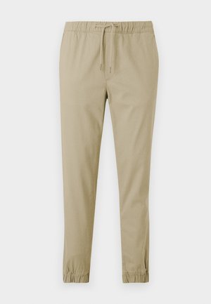 Lichtbeige, taps toelopende broek met een elastische tailleband en trekkoord. Soepele katoenstof met elastische boorden bij de enkels.