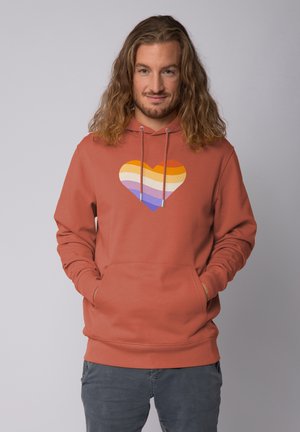 Roestkleurige hoodie met een voorkeurszak, voorzien van een meerkleurige gestreepte hartafbeelding. Gemaakt van zachte stof met een casual pasvorm.