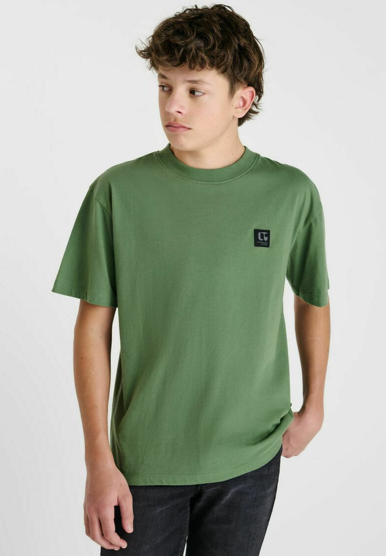 T-shirt en cotton vert à manches courtes et col rond. Présente une petite patte de logo noire sur la poitrine gauche. Texture lisse.