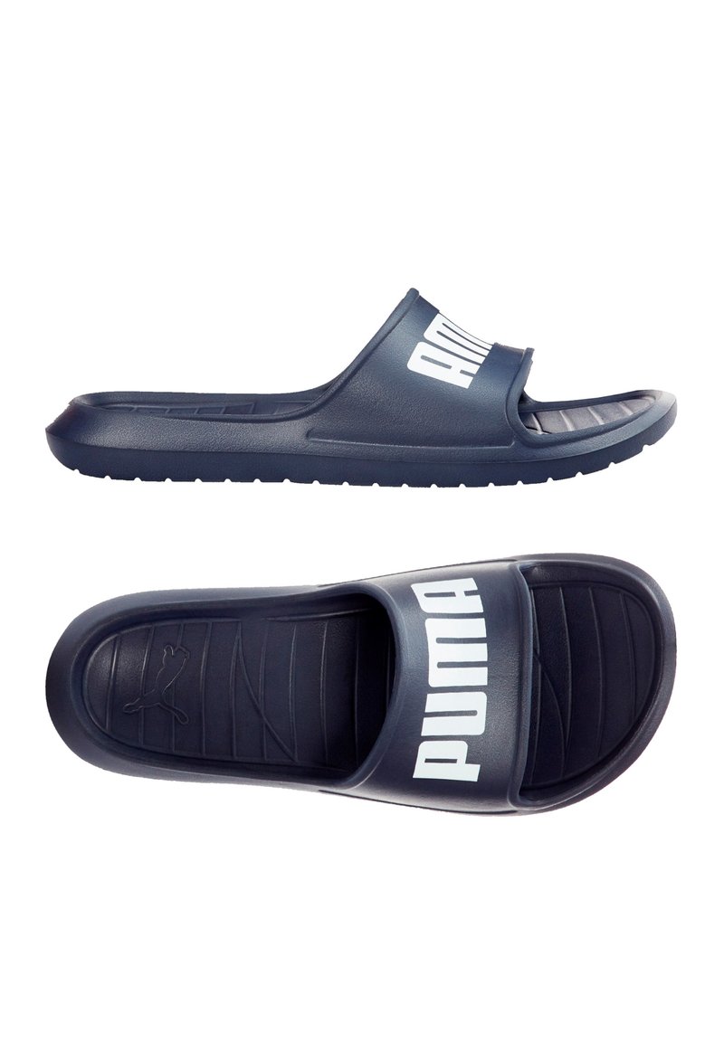 Sandales bleu marine à bout fermé et talon ouvert. Elles possèdent une large sangle avec "PUMA" en lettres blanches et une semelle intérieure texturée.