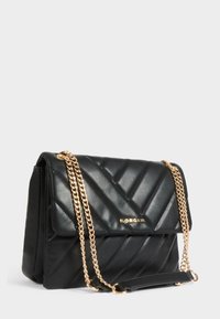 Borsa a tracolla nera in ecopelle trapuntata con catene dorate e logo dorato. Presenta una chiusura a pattina e un motivo a chevron testurizzato.