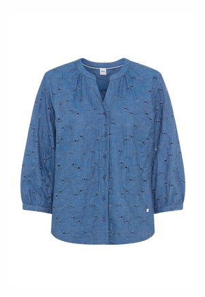 Blouse boutonnée bleue avec broderie florale en œillets, manches longues avec poignets élastiques et encolure ronde.