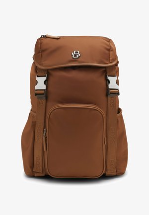 Bruine nylon rugzak met verstelbare schouderbanden, een voorzak met rits en een klep bovenop. Voorzien van metalen hardware en logo-details.