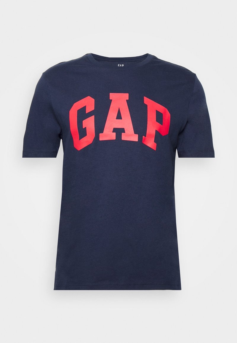 T-shirt bleu marine à manches courtes avec de grandes lettres rouges "GAP" imprimées sur la poitrine.