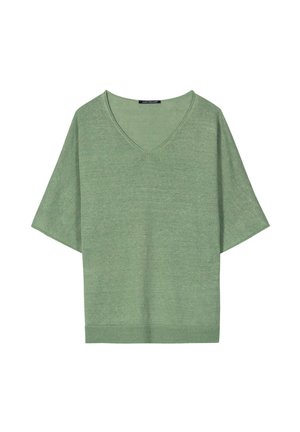 Green short-sleeve knit top with V-neck and loose fit, featuring a ribbed hem and a clothing label at the neckline.