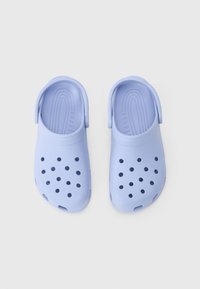 Svijetloplavi klompi bez peta s naramenicama i ventilacijskim otvorima, prikazani odozgo na bijeloj pozadini.