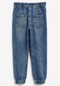 Joggers in denim azzurro chiaro con vita elasticizzata, polsini arricciati e due tasche posteriori. Presentano una finitura sbiadita e testurizzata.